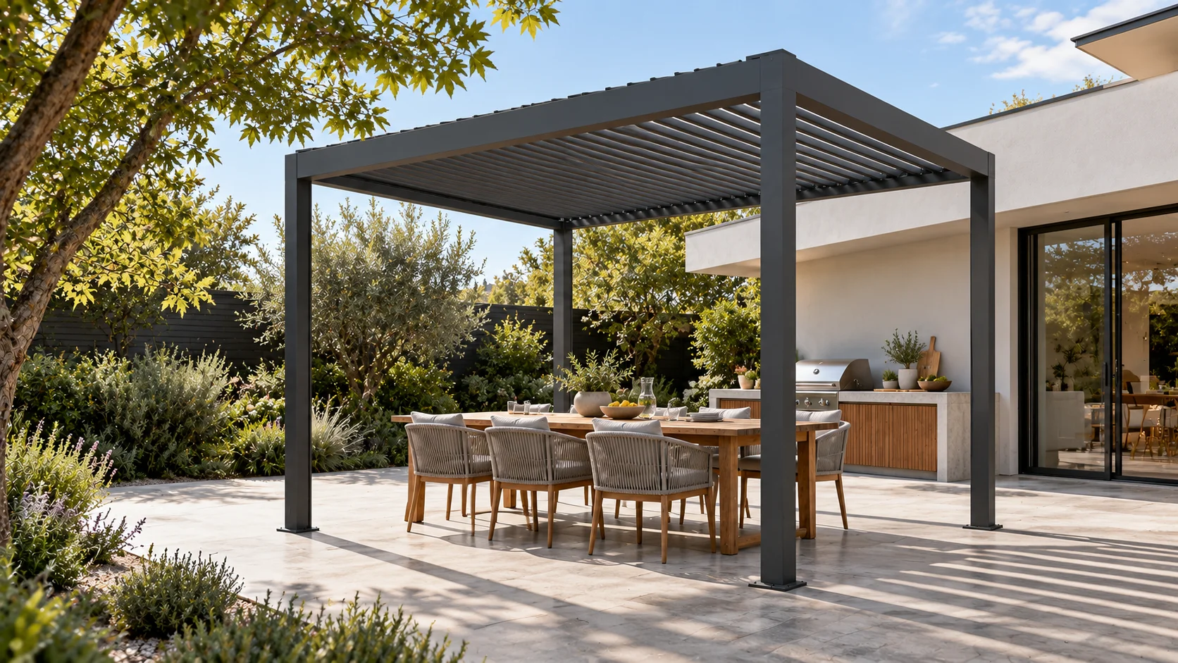 Pergola LUMINA antracite con zona pranzo accanto a una cucina esterna