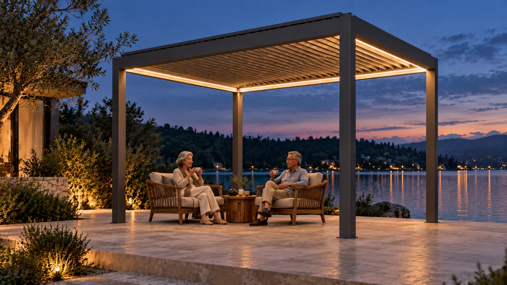 Una coppia si rilassa sotto la pergola LUMINA antracite con LED in riva al lago